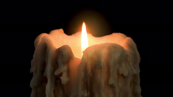 An old and melted candle rotates in front of a black background alt