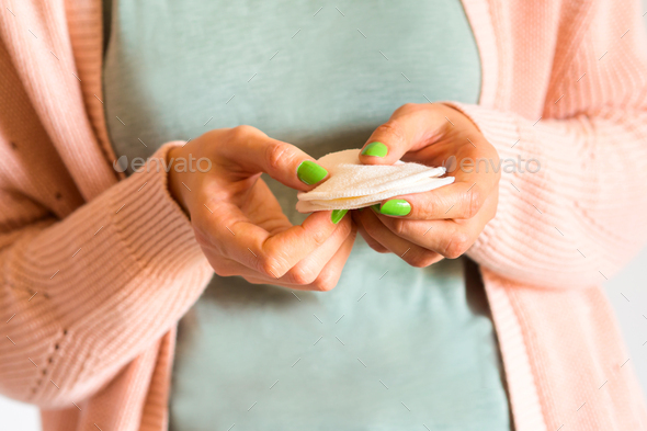 Woman pastel clothes holding reusable cotton pads