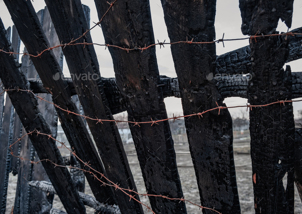 Burnt fence with barbed wire