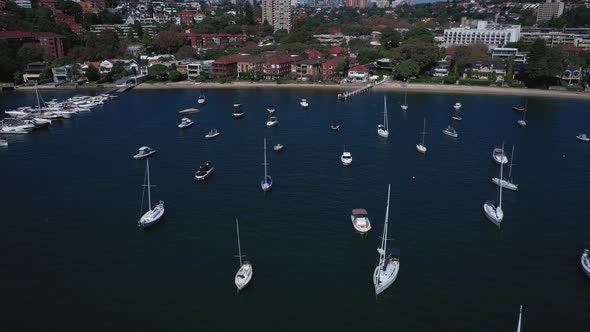 Sydney Harbor on a beautiful sunny day from Double Bay featuring boats, blue sky and water. Drone tr alt