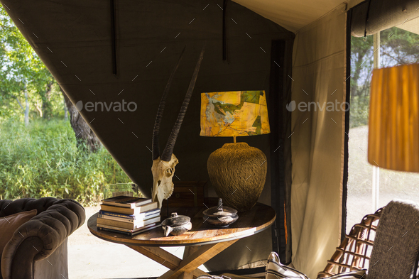 The interior of a tent in a safari camp, tent sides rolled up.