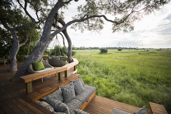 Wooden platform overlooking scenic landscape at a tented safari camp.