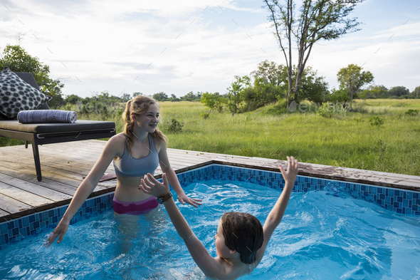 Brother and sister, Two children swimming in small pool at a safari camp