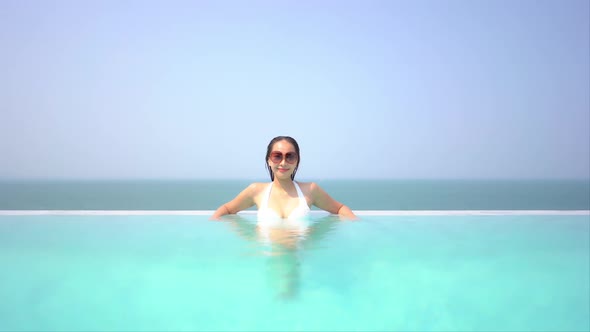 Young asian woman enjoy around outdoor swimming pool for leisure alt