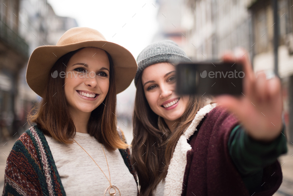 Women taking selfies Stock Photo by TrendsetterImages | PhotoDune