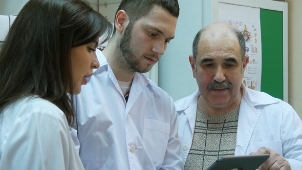 Pharmacists Using Digital Tablet While Checking Medicine