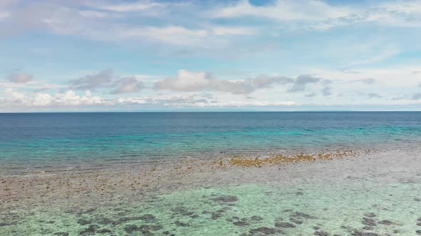 tropical shallow blue ocean waves washing up on coral in the Pacific drone footage alt