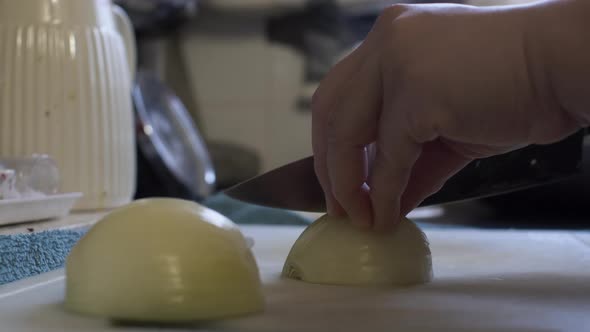 Adult Female Hands Slicing Onions On Chopping Board In Home Kitchen. Low Angle, Locked Off alt
