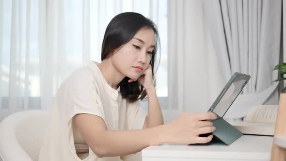 A smart freelance woman typing a promotional message on her website through a tablet she worries abo alt