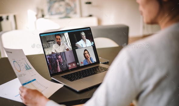 Woman discussing business with team over a video conference - Stock Photo - Images