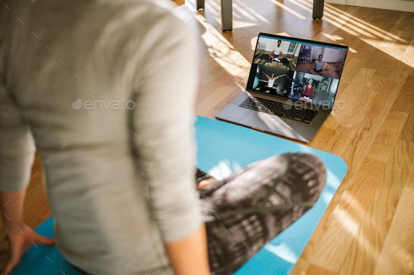 Group of people practicing yoga via video conference - Stock Photo - Images