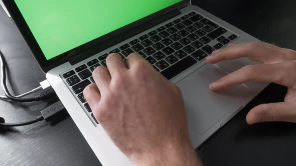 Person is using chroma key green screen laptop computer. alt