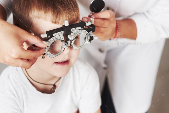 Child sitting in the doctor\'s cabinet and have tested his visual acuity