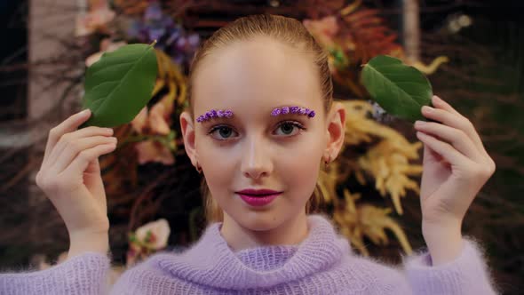 Smiling Girl with Green Leaves Front Eyes with Flowers Makeup alt