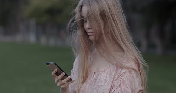 Beautiful young girl is looking at the phone