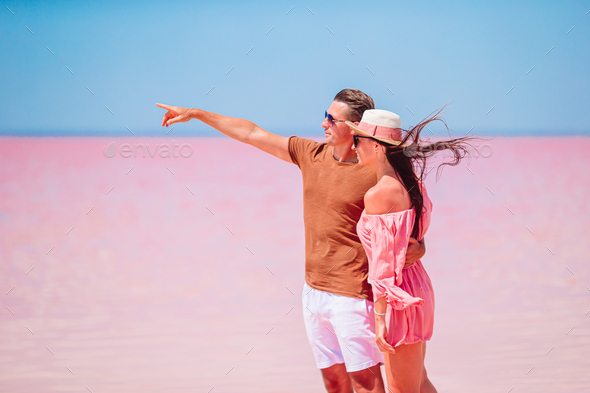 Family walk on a pink salt lake on a sunny summer day