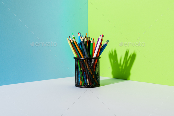 Pencil Holder With Colored Pencils on Blue, Green And White Background