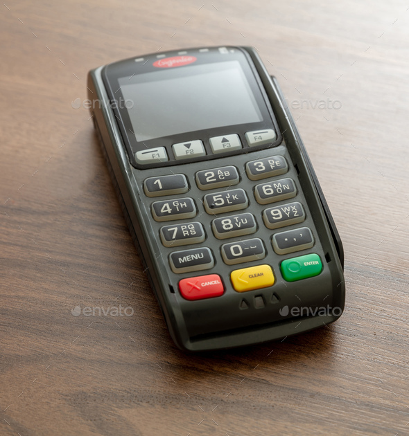 Payment machine, POS terminal on wooden background.