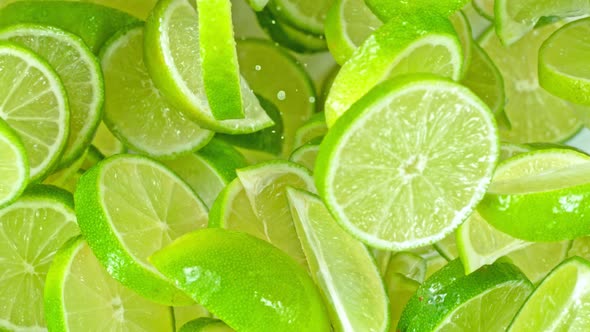 Super Slow Motion Shot of Flying Fresh Lime Slices Towards Camera at 1000Fps alt