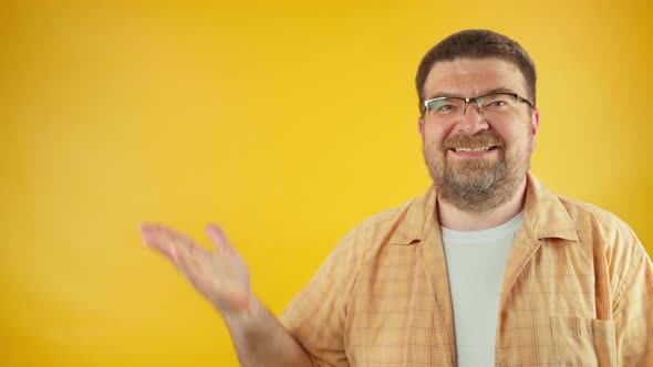 Excited cheerful laughing bearded adult man pointing thumb finger aside on empty palm alt