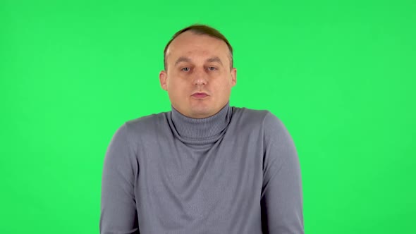 Portrait of Displeased Man Indignantly Talking To Someone, Looking at the Camera. Green Screen alt