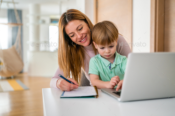 Mother working at home-office with child on her lap