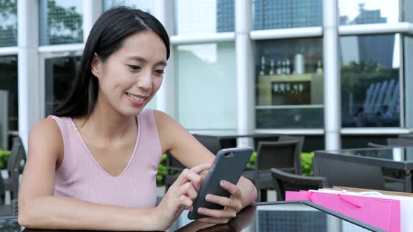 Woman Using Cellphone in Outdoor Cafe alt