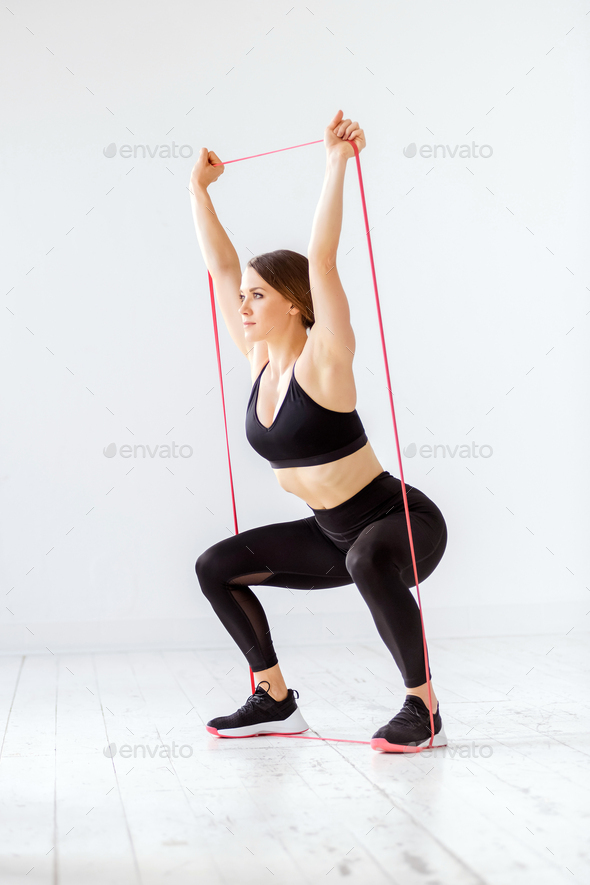 Fit young woman doing a power band squat