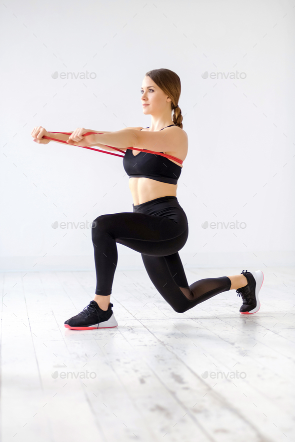 Woman doing a power band behind lunge forward push