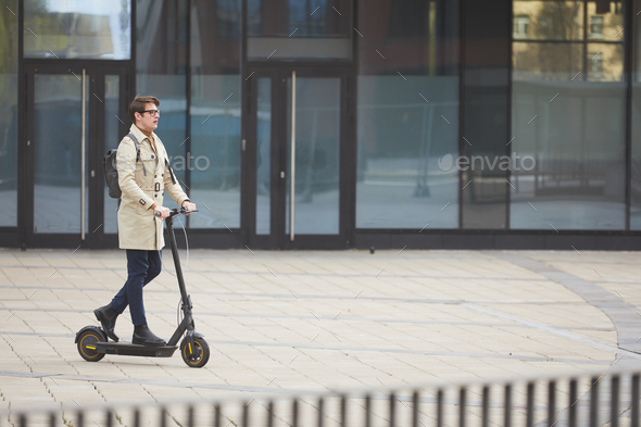 Man Riding Electric in City Stock Photo by seventyfourimages