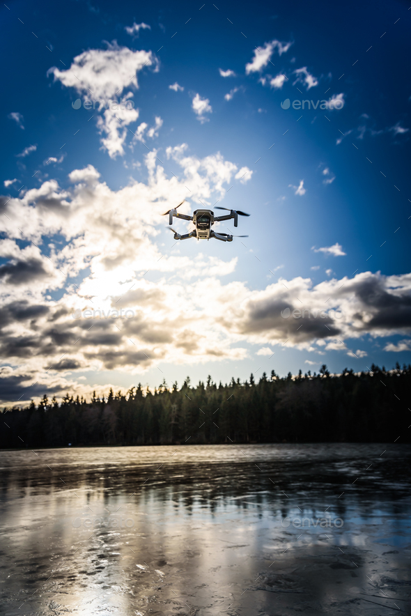Graz, Austria - December 29 2019. DJI Mavic Mini drone flying in the countryside above frozen lake