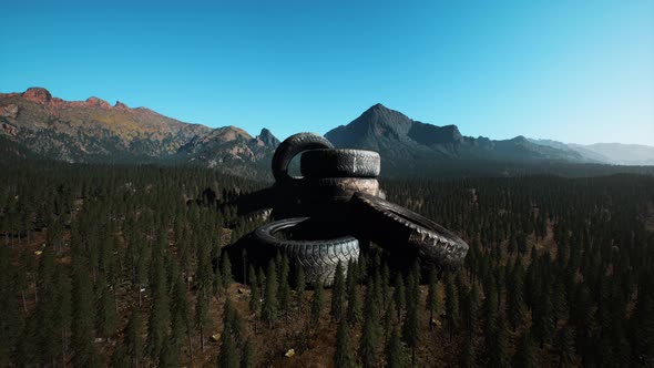 Concept of Environmental Pollution with Big Old Tires in Mountain Forest alt