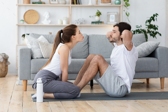 Active young couple exercising together at home
