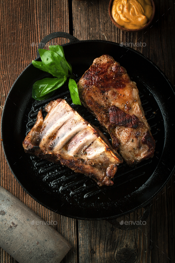 Grill Pork ribs with ketchup, mustard in a frying pan Stock Photo by