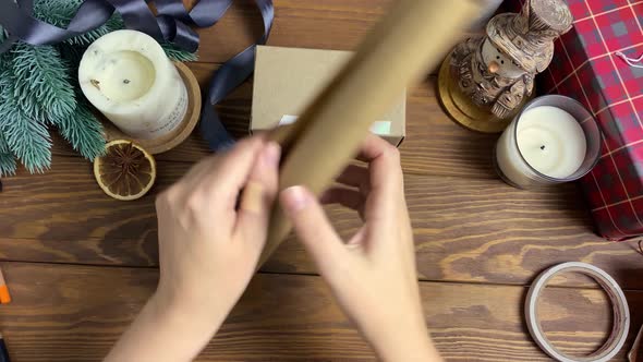 Packaging of Christmas Gift on Wooden Table