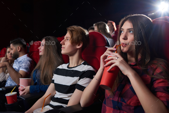 Friends watching interesting film at big cinema hall