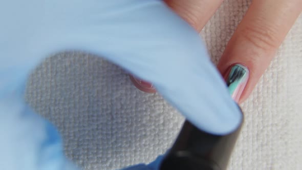 Young Woman Paints Her Nails with Natural Blue Gel Base. Nails Manicure.  alt