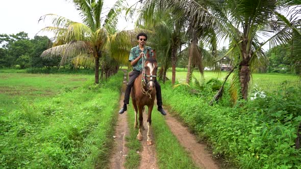 Young handsome man with brown horse. man riding horse alt