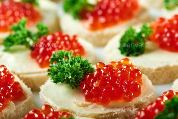 Canapees with red caviar and parsley - Stock Photo - Images