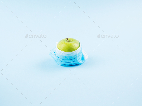 Green fresh apple in face mask. Covid19 concept