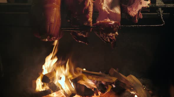 Big Piece of Meat Coocked on Open Fire and Some Pork Pieces Grilled at Historical Medieval Festival alt