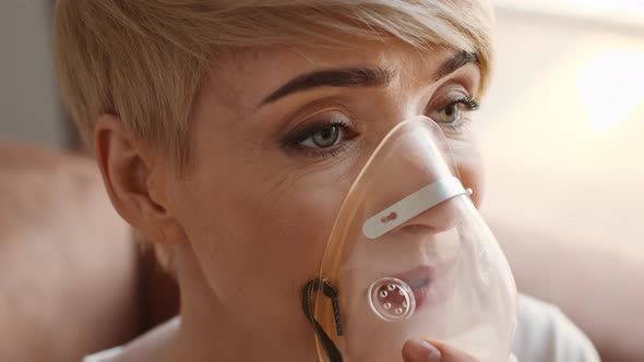 Sick Woman Breathing Through Inhalator Mask Having Respiratory Disease Indoors alt