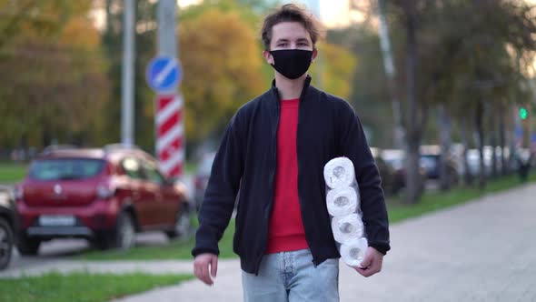 Teen Walking in Medical Mask with Toilet Paper During the Second Wave Quarantine Coronavirus COVID alt