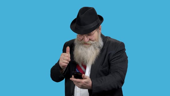 Mature Businessman Looking at Mobile Phone. alt