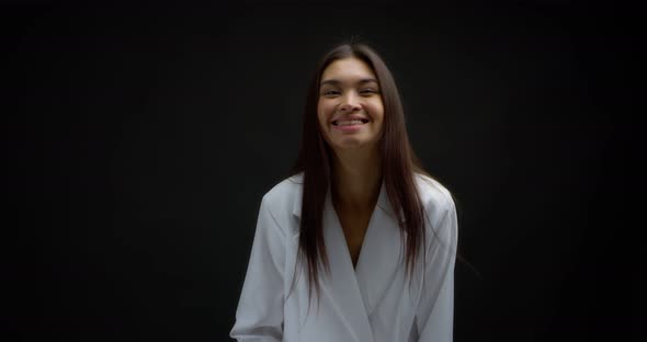 Horizontal Shot of a Happy Asian Woman Laughing on an Isolated Black Background alt