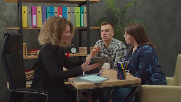 Focused Couple with Woman Estate Agent Selecting Housing Options on Tablet Pc alt