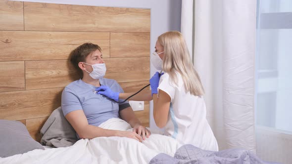 Professional Female Doctor is Listening to Breath of Male Patient