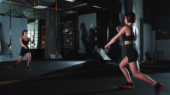 A Strong Tattooed Woman Exercising Karate Moves in Front of a Mirror alt