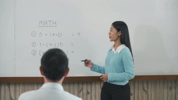 Young asian teacher teaching students at classroom.