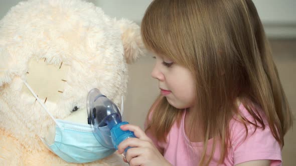Little Girl Does Procedure with Medication Nebulizer and Heals Friend Toy Teddy Bear in Medical Mask